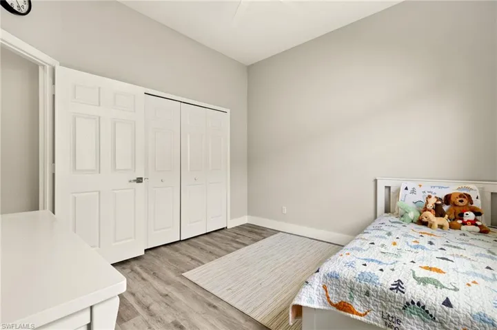 Bedroom with a ceiling fan, light wood-style flooring, baseboards, and a closet