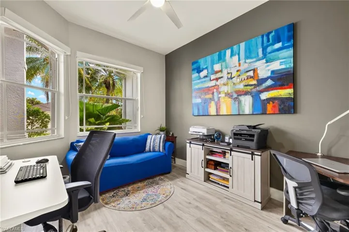 Home office featuring light wood-style floors, a wealth of natural light, ceiling fan, and baseboards.