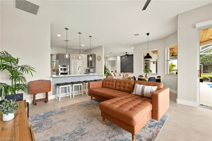 Living area featuring modern vents, ceiling fan, and light 30x 30 tile floors.
