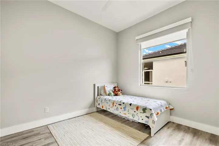 Bedroom with ceiling fan, baseboards, and wood finished floors
