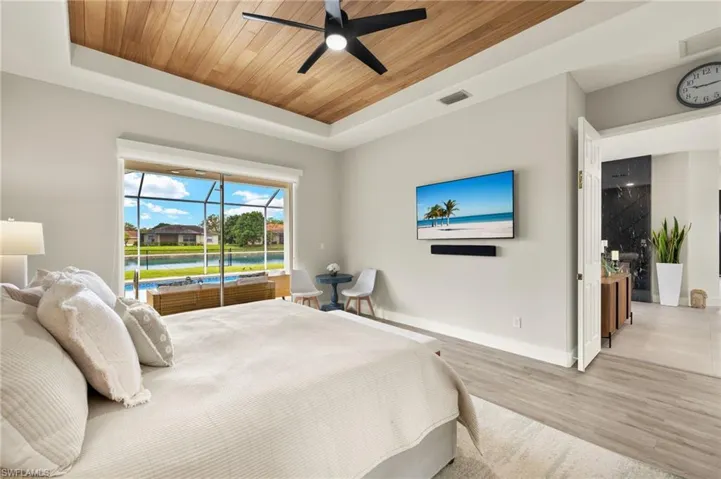 Bedroom featuring a sunroom, a raised ceiling, wooden ceiling, and wood finished floors