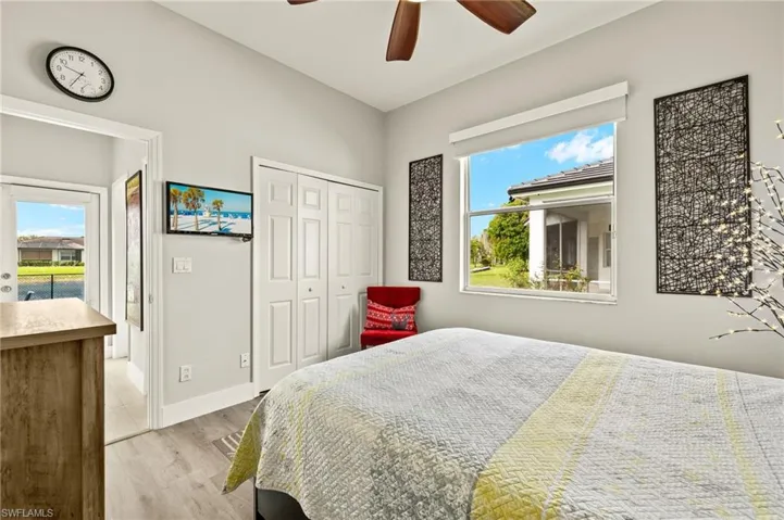 Bedroom featuring light wood finished floors, a ceiling fan, baseboards, and a closet