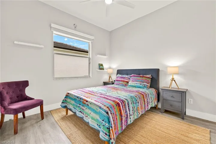 Bedroom featuring wood finished floors, a ceiling fan, and baseboards