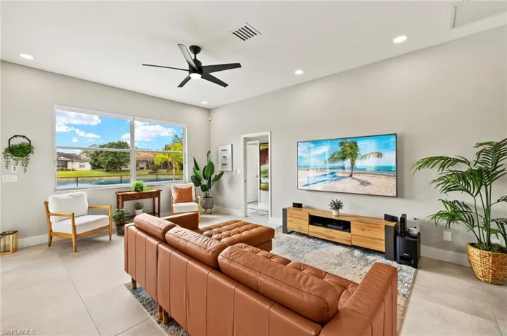Living area with a ceiling fan, recessed lighting, visible vents, and 6in baseboards throughout.