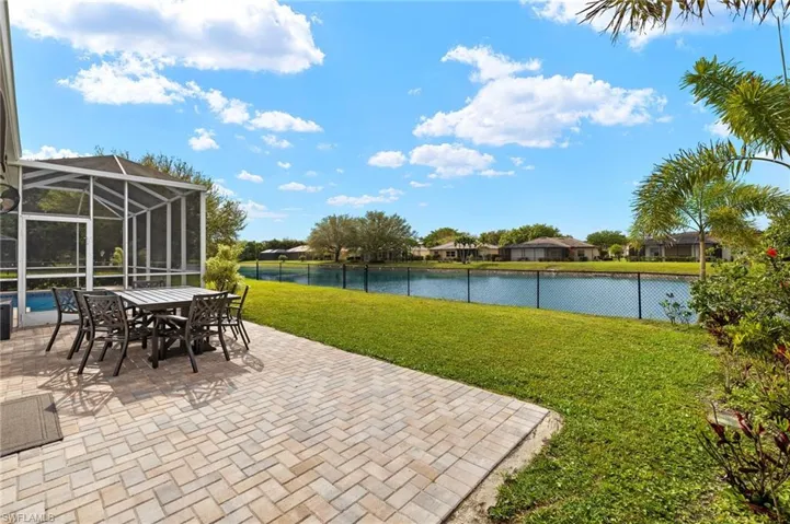 View of patio / terrace with an outdoor pool,  a water view, and fence