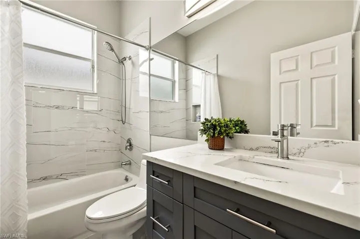 Bathroom with vanity, shower / bath combo with shower.