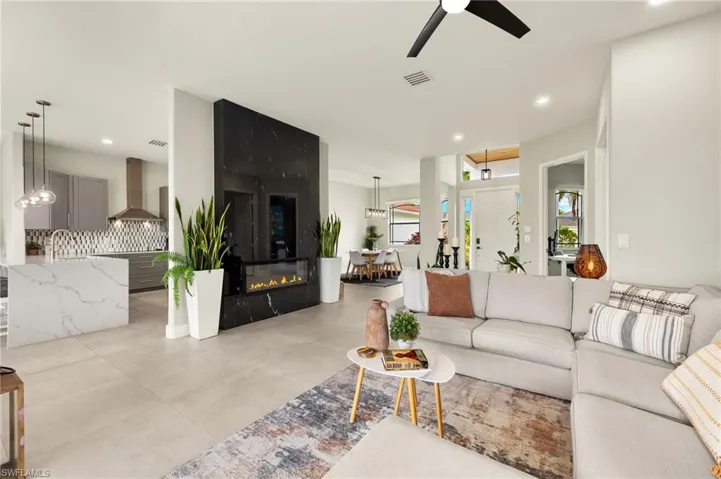 Living area featuring a ceiling fan, a granite fireplace, visible vents, and recessed lighting