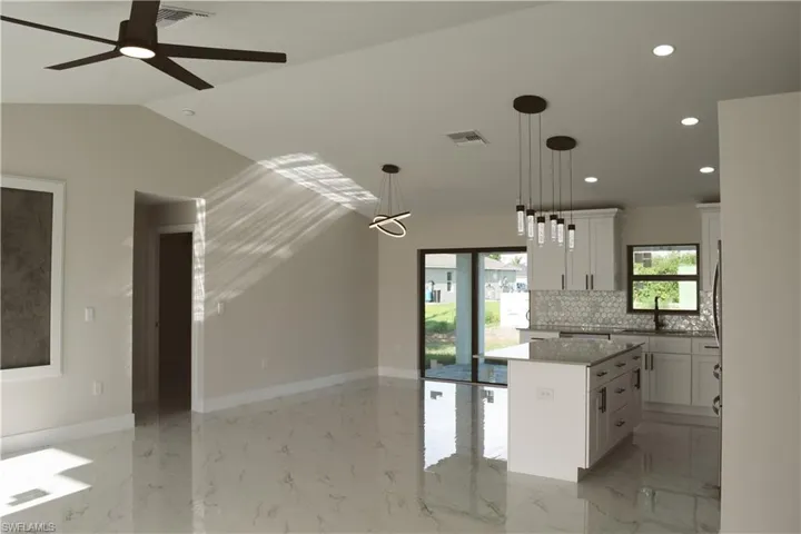 Kitchen featuring a center island, recessed lighting, white cabinetry, backsplash, and pendant lighting