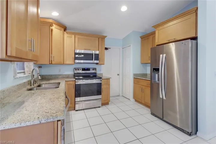 Natural wood cabinets with stainless steel appliances