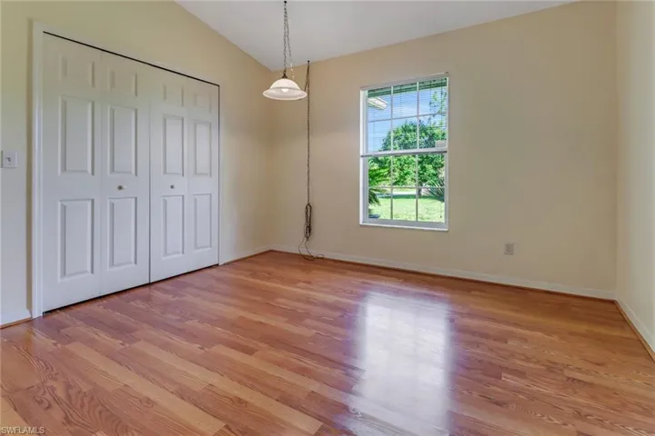 Guest bedroom with wood flooring