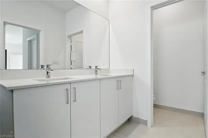 Bathroom featuring double vanity and toilet