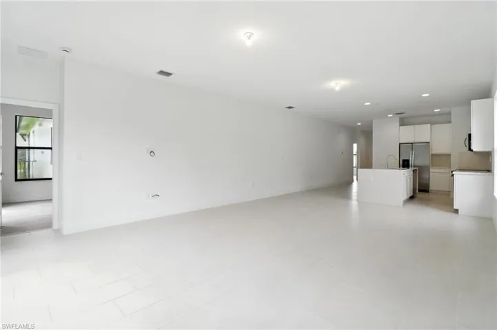 Unfurnished living room featuring recessed lighting and a sink