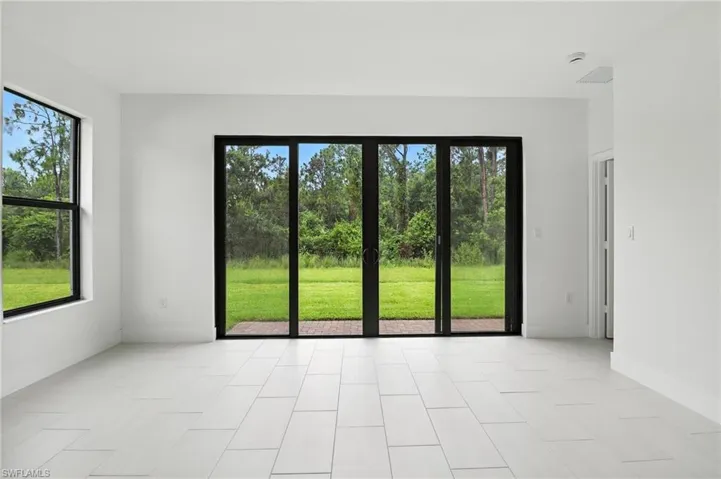 Empty room with a smoke detector and baseboards