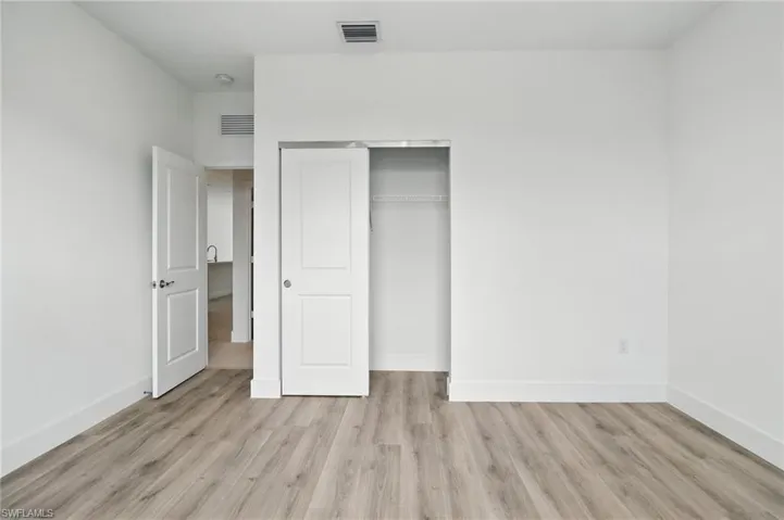Unfurnished bedroom featuring light wood-type flooring and a closet