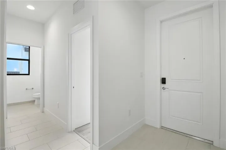 Hallway with baseboards and recessed lighting