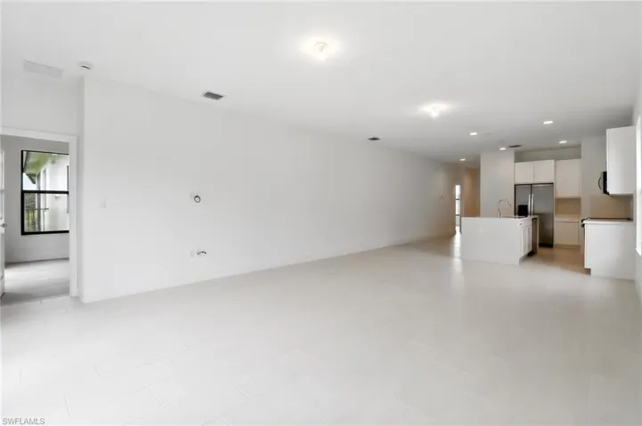 Unfurnished living room with recessed lighting and a sink