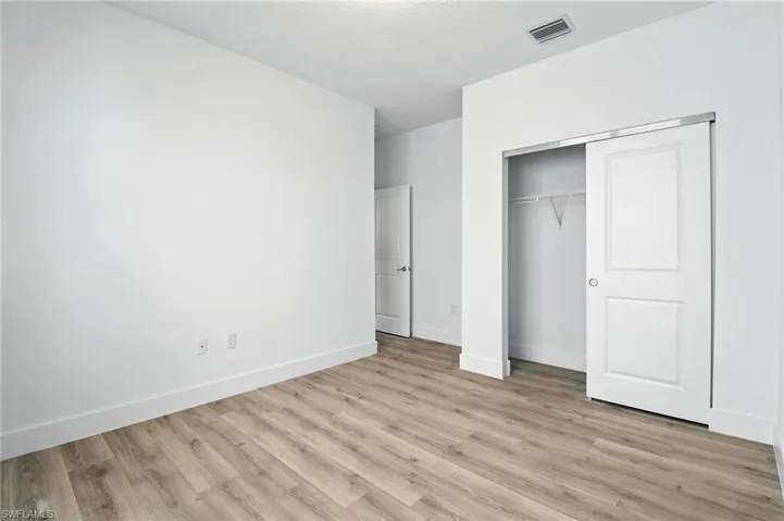 Unfurnished bedroom featuring light wood finished floors and a closet