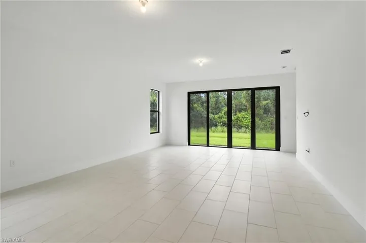 Empty room featuring light tile patterned floors and baseboards