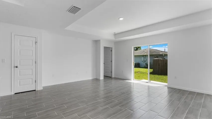 Spare room with a tray ceiling, wood tiled floors, and recessed lighting