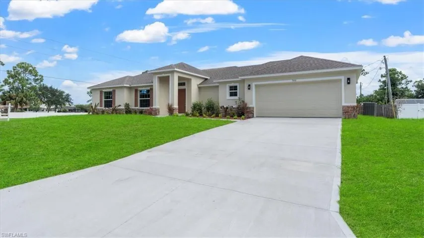 View of front facade with an attached garage, stone siding, concrete driveway, stucco siding, and roof with shingles