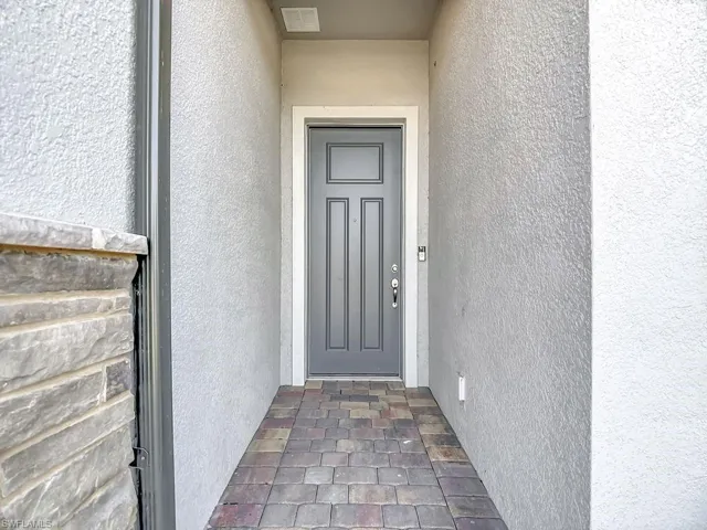 Entrance to property with stucco siding