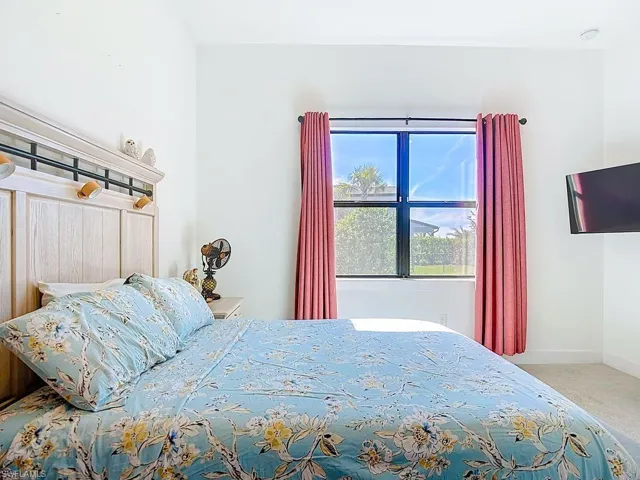 Bedroom featuring baseboards and light carpet