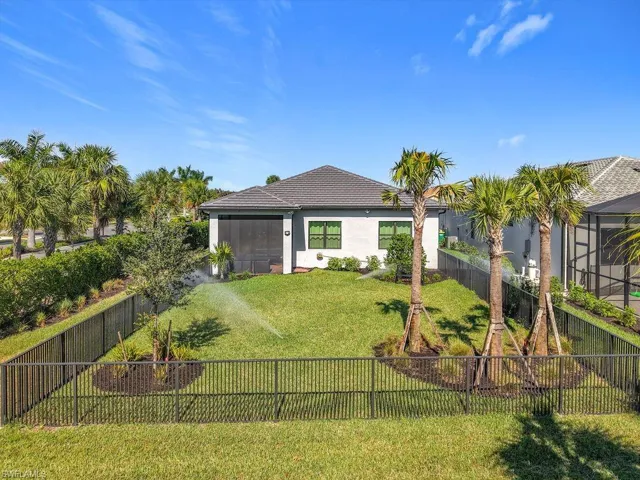 Back of house with a sunroom, a fenced backyard, and stucco siding