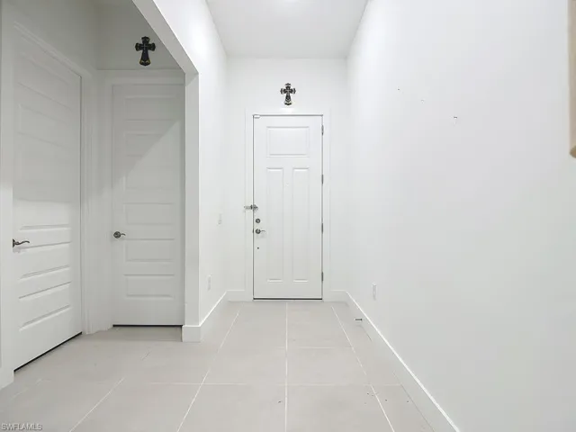 Doorway featuring baseboards and tile patterned flooring