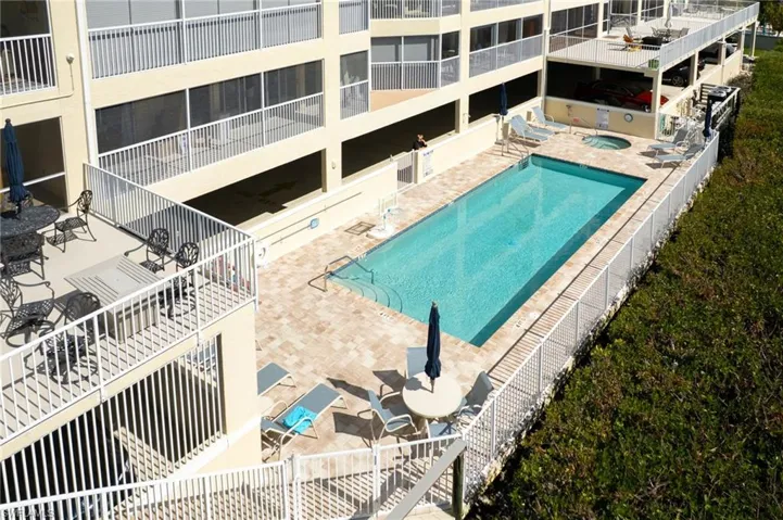Sparkling bayside pool and spa. Stairs lead up to Community Room/BBQ/Restrooms.