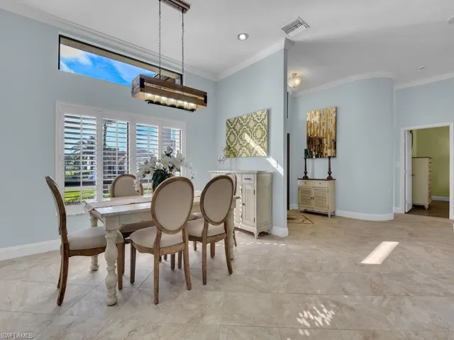 Dining space with visible vents, baseboards, and crown molding