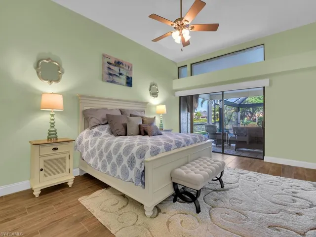 Bedroom with baseboards, access to outside, wood finished floors, and a ceiling fan