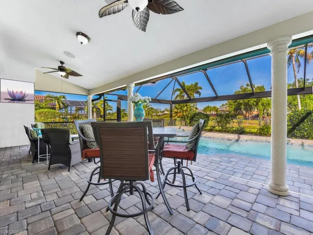 View of patio featuring a fenced in pool, outdoor dining area, glass enclosure, and ceiling fan