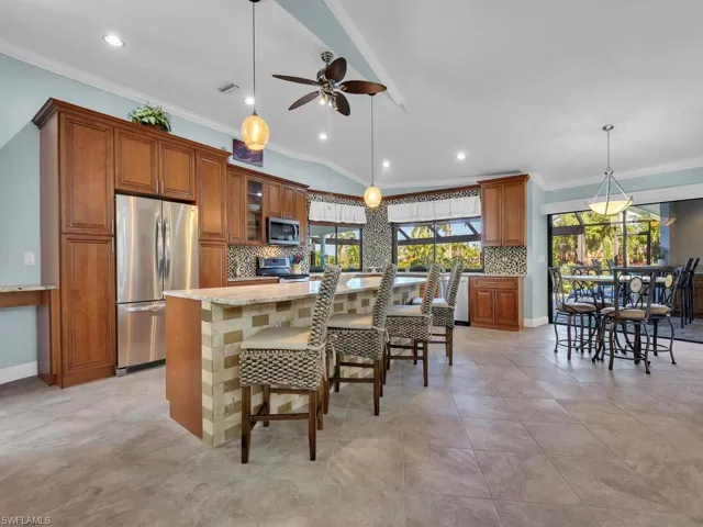 Kitchen with visible vents, ceiling fan, brown cabinetry, and appliances with stainless steel finishes