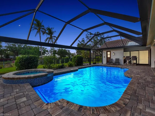 View of swimming pool with a patio, a pool with connected hot tub, and a lanai