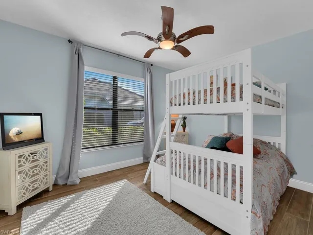 Bedroom with wood finished floors, baseboards, and a ceiling fan