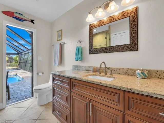Bathroom with tile patterned floors, vanity, walk in shower, and toilet