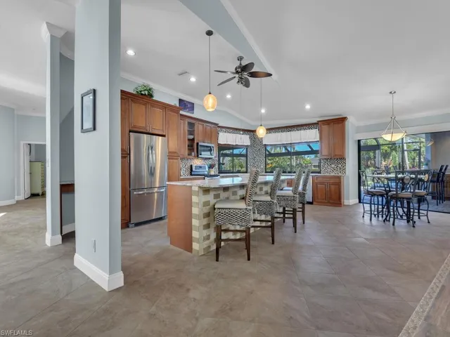 Kitchen with plenty of natural light, a ceiling fan, brown cabinets, stainless steel appliances, and a kitchen island