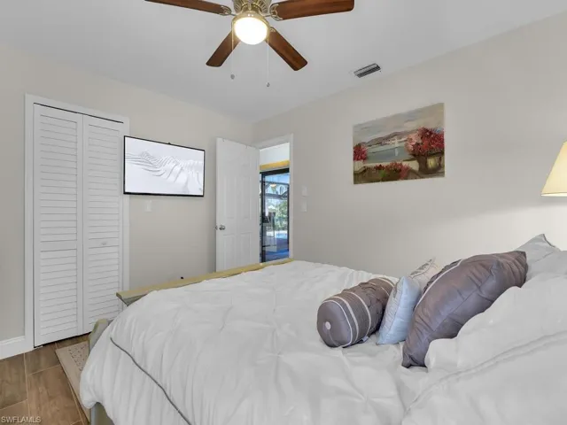 Bedroom with visible vents, a closet, a ceiling fan, and wood finished floors
