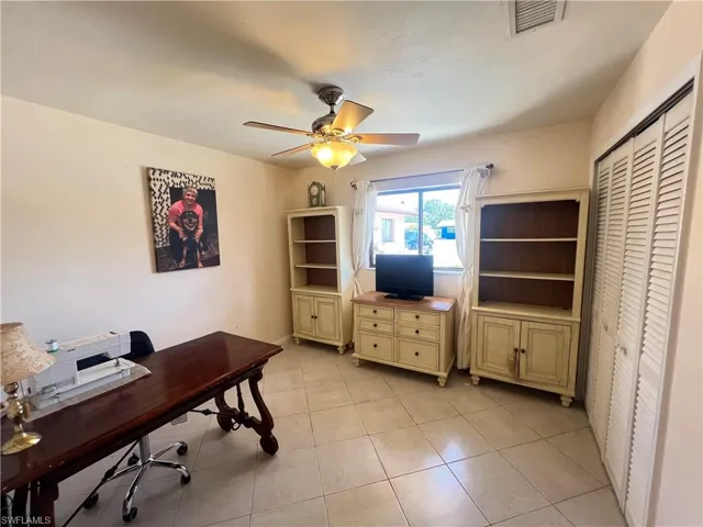 Office space with ceiling fan and light tile floors