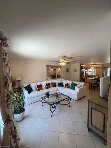 Living room featuring ceiling fan and light tile flooring