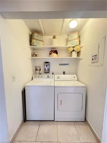 Laundry room with separate washer and dryer, hookup for a washing machine, light tile floors, and electric dryer hookup