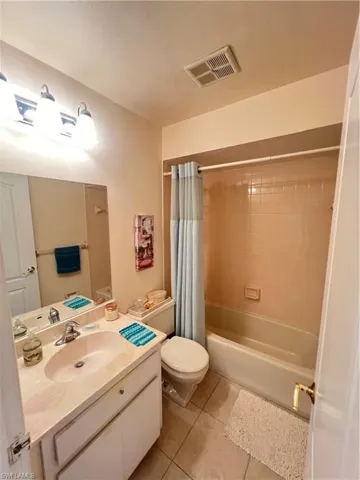 Full bathroom with tile flooring, vanity, toilet, and shower / tub combo