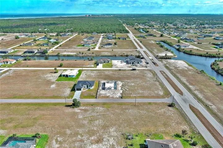Aerial overview of property's location with a large body of water and a forest
