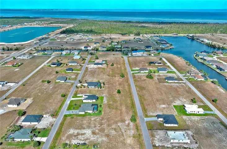 Aerial view of property and surrounding area with a nearby body of water and nearby suburban area