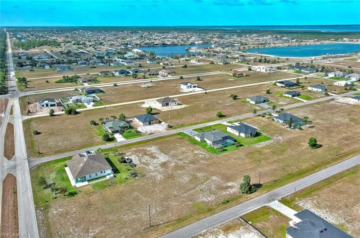 Aerial perspective of suburban area featuring a nearby body of water