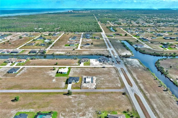View of property location featuring a nearby body of water and a forest