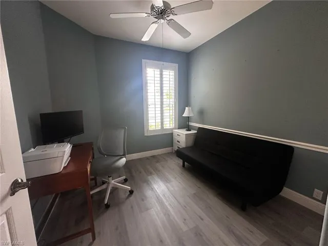 Office area with wood finished floors and ceiling fan