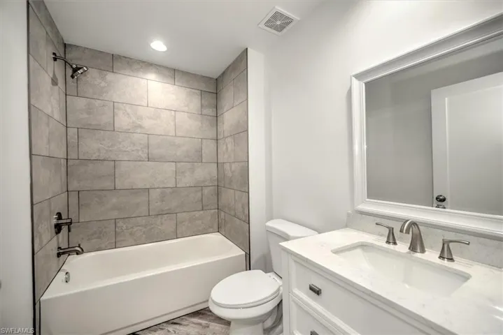 Guest bath with a tub and 12 x 24 tile up to the ceiling
