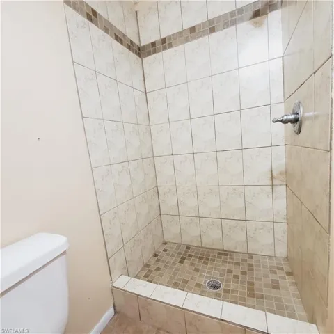 Bathroom featuring a stall shower and toilet
