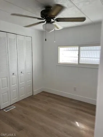 Unfurnished bedroom featuring a closet, hardwood / wood-style flooring, and ceiling fan